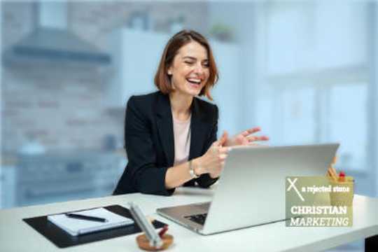 Business woman looking at her laptop and thrilled with the results she is seeing